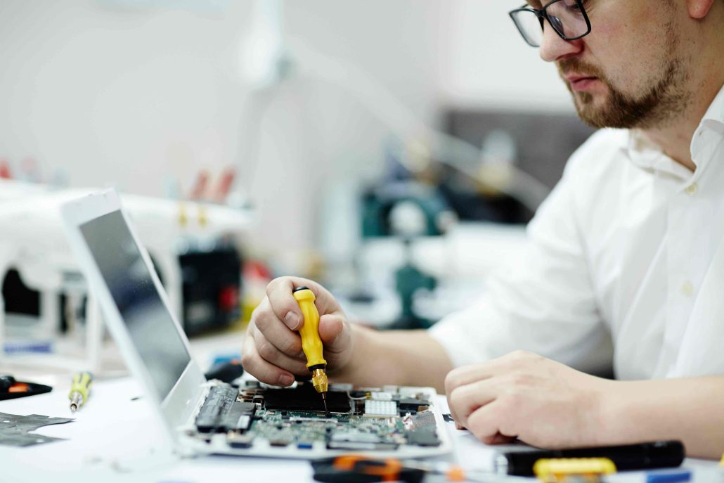 man repairing computer circuit board laptop